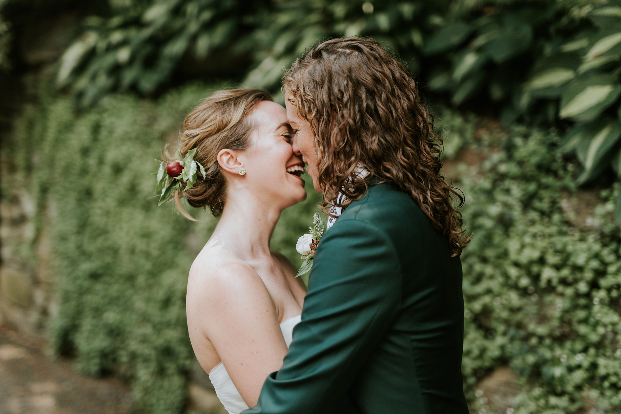 A newlywed couple laughing together during a quiet garden portrait