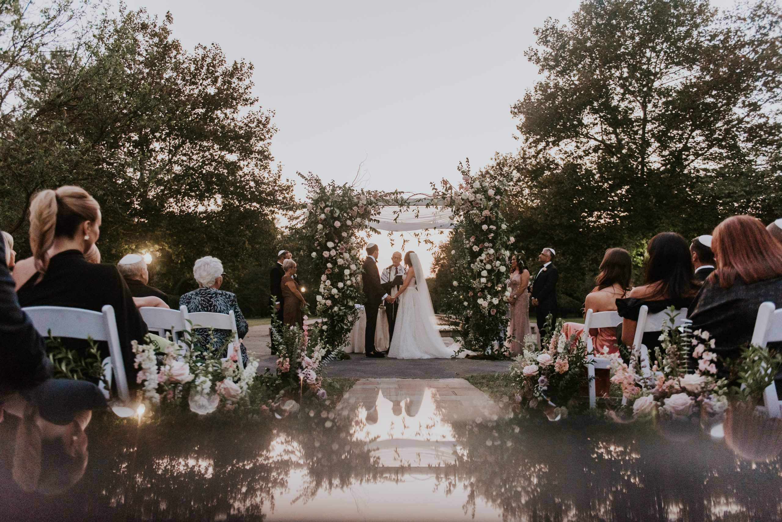 A garden wedding ceremony reflected in still water at the Horticulture Center