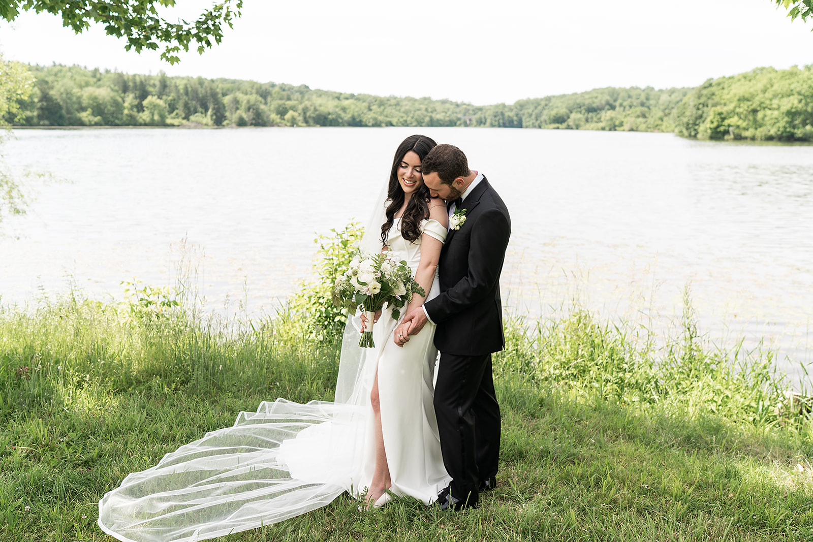 Mackenzie and Zach standing together beside the lake at the Lake House Inn